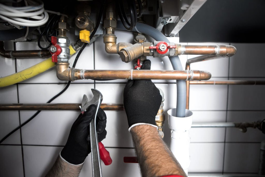 plumber working at home, work at the heating installation PLUMBING